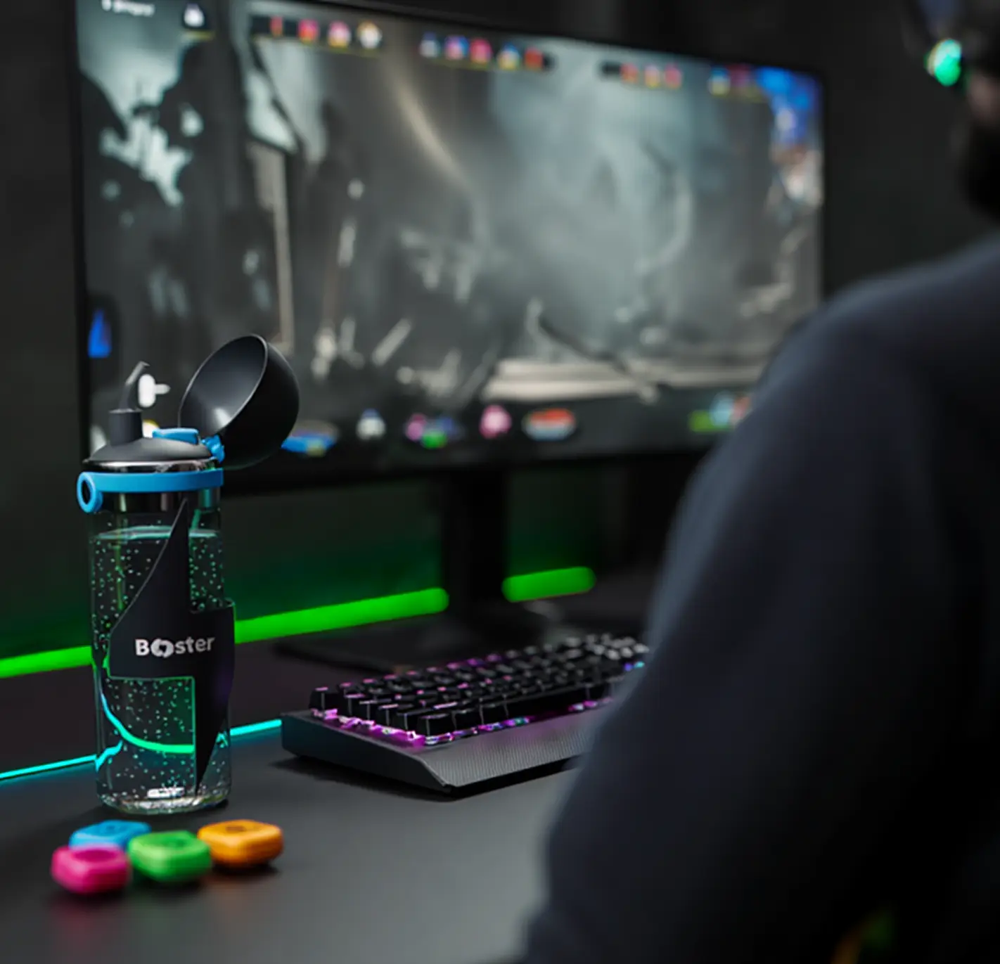 Image décorative d'un gamer jouant sur son ordinateur avec la gourde wooter posée à côté de lui